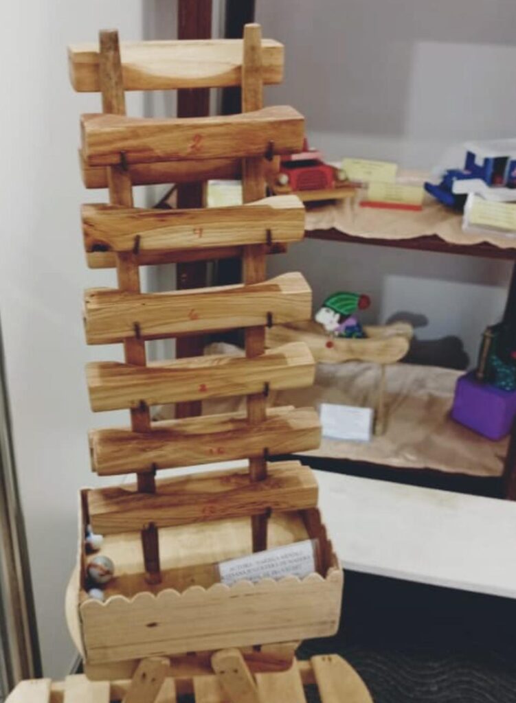 En esta escalera de madera hay metras que caen de peldaño en peldaño y producen música