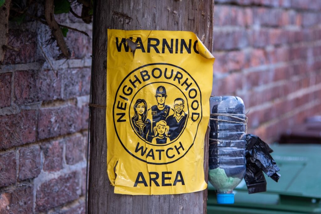Neighborhood watch warning sign on a pole representing community safety and citizen alert systems