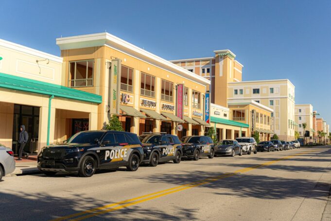 Police cars lined up on a sunny street outside buildings - Photo by Unsplash